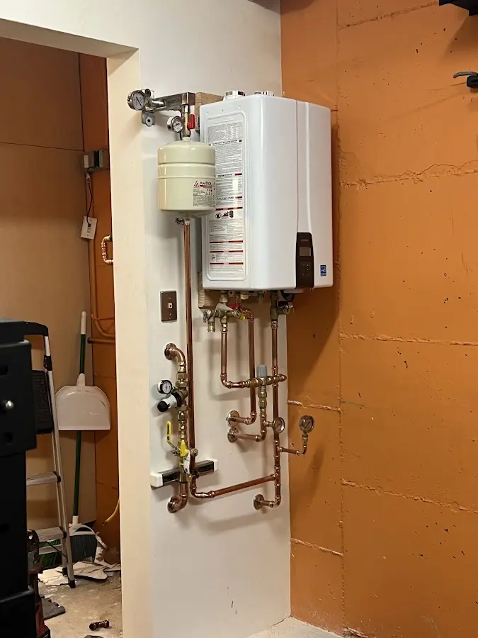 Plumbing technician inspecting water heater connections in Swatara